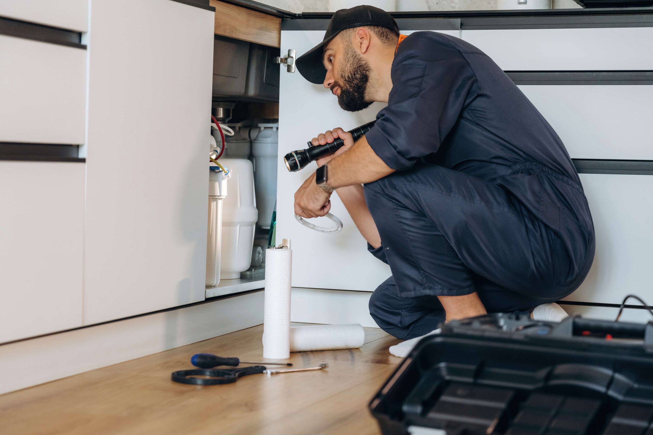 plumber-working-in-the-kitchen-under-the-sink