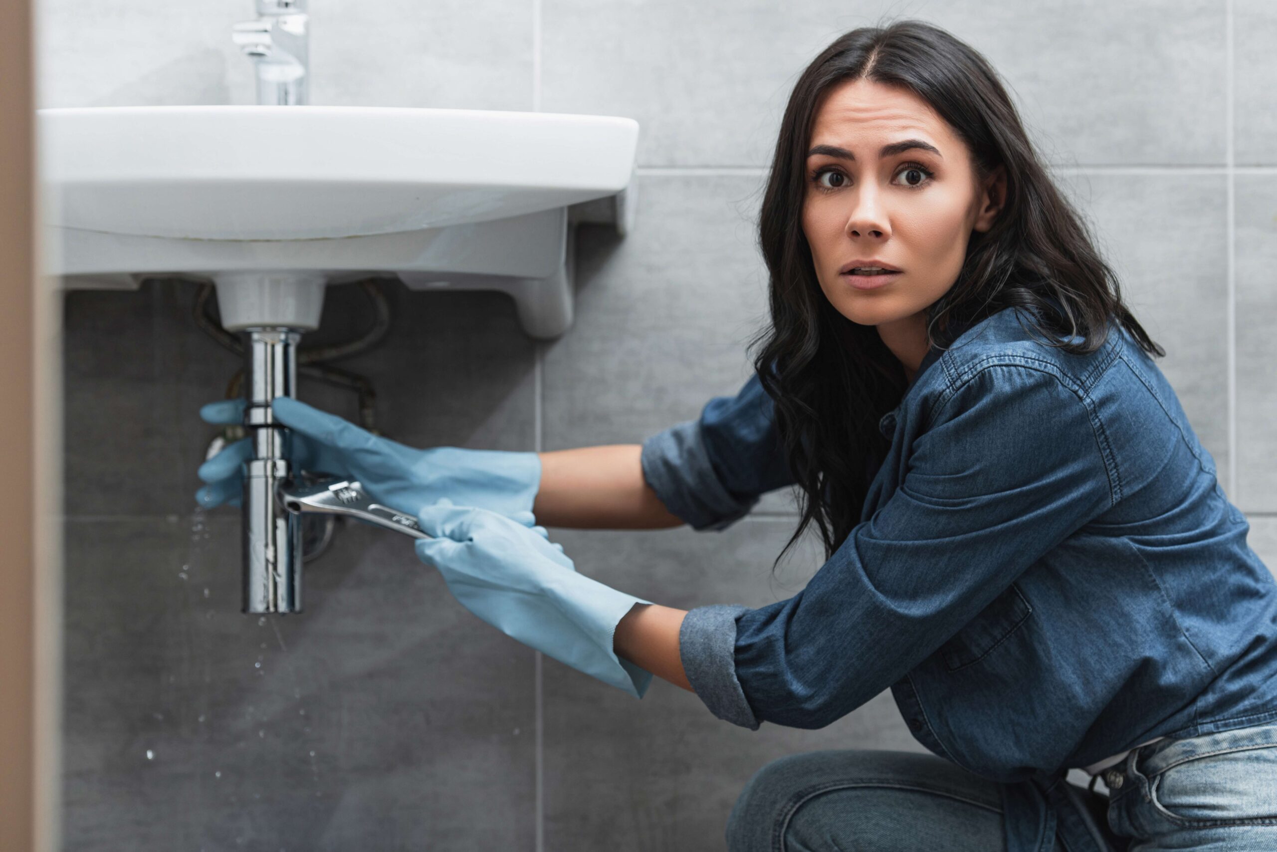 http://worried-woman-in-rubber-gloves-repairing-pipe